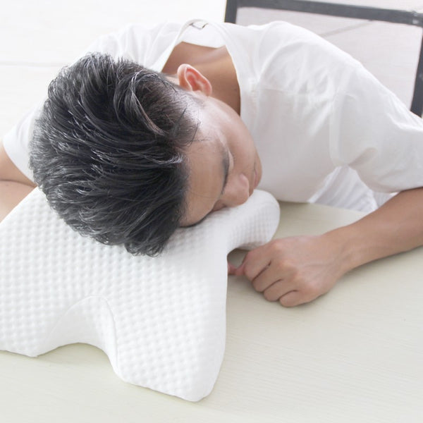 Male lying side of head on Slow Rebound Pressure Foam Pillow on top of desk